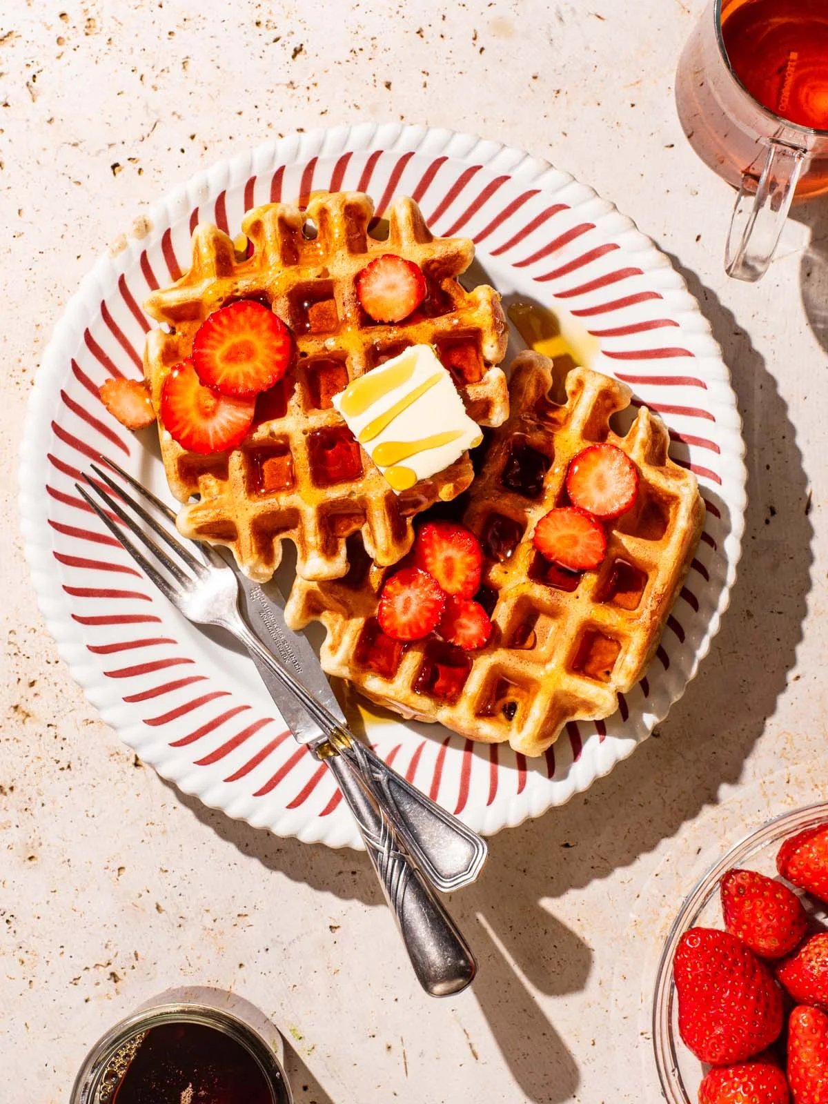 Golden spelt sourdough waffles topped with strawberries and butter at Waco Waffle Co.